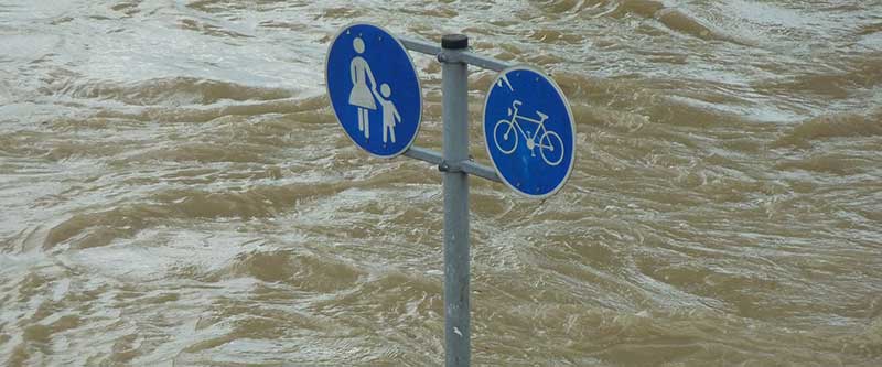 crossing sign for bikes and children in flood water